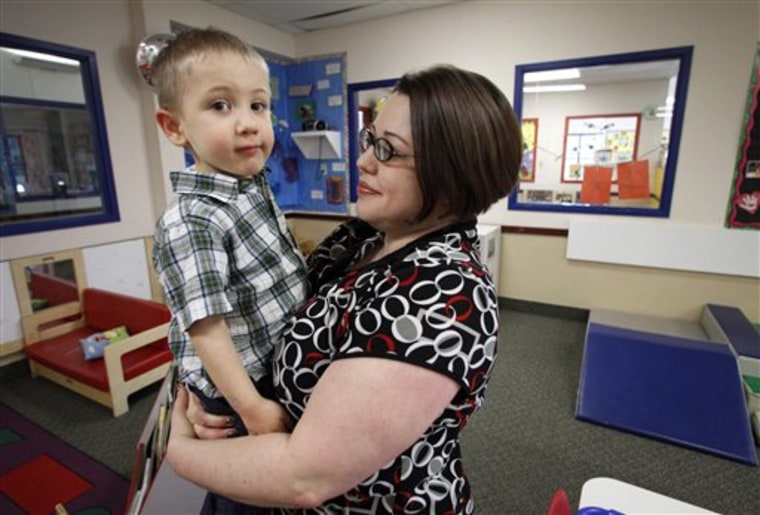 In this April 4, 2012, photo, Kelly Andrus holds her son Bradley in his classroom at Children's Choice Learning Centers Inc., in Lewisville, Texas. Bradley, who turns three in a couple of weeks, was diagnosed a year ago with mild autism. For the first time in nearly two decades, experts want to rewrite the definition of autism. Some parents fear that if it's narrowed and their kids lose the label, they may also lose out on special therapist. (AP Photo/Tony Gutierrez)